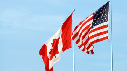 United States and Canadian flags waving side by side